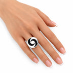 Yin-yang spinning top ring on hand with glossy black-and-white top