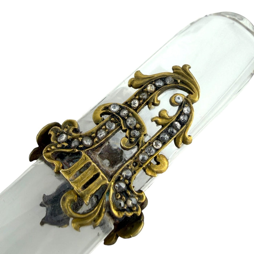 Letter opener close-up: ornate gold-tone handle with diamond-like accents on clear blade