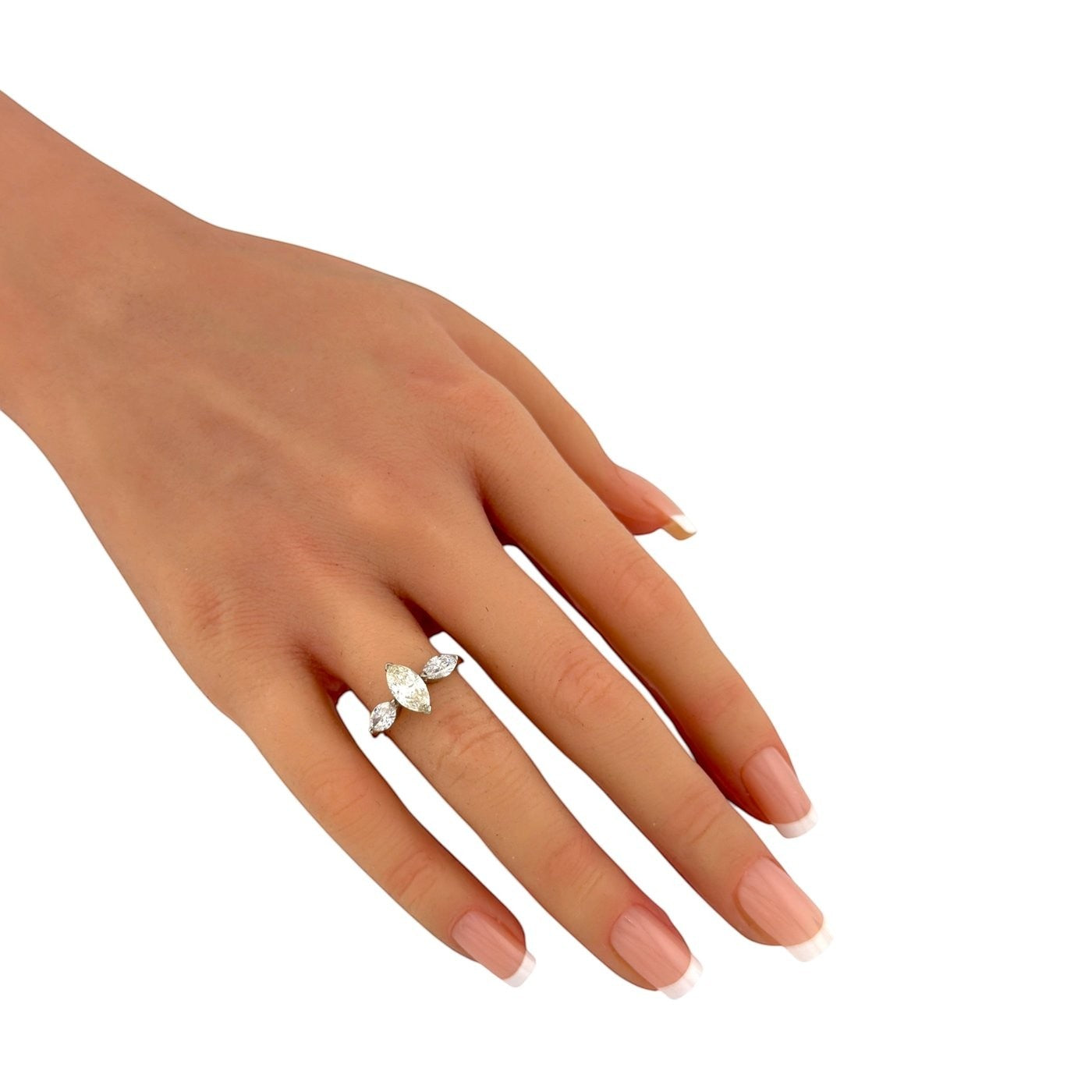 Rose gold marquise diamond ring on finger with three-stone cluster