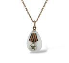 Teardrop enamel egg pendant with striped ribbon and gold flower insignia on chain