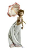 Porcelain figurine of a woman holding a pink fan-like parasol and white gown