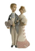 Porcelain wedding couple figurine, groom in gray suit holding hat, bride in pink lace dress