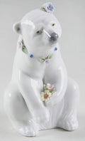 White polar bear figurine resting with painted flowers and blue accents