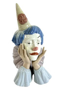 Lladro jester porcelain figurine with blue wig, pale face, and raised hands
