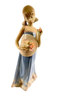 Porcelain girl figurine holding a flowered bowl, blue skirt with floral hem