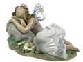 Porcelain fairy princess figurine seated with heart fan, pink dress, green wings