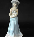 Porcelain figurine of woman in light blue dress holding a white lamb