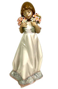 Porcelain figurine of a girl holding a spring flower bouquet, white dress