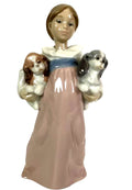 Porcelain figurine of a girl in pale pink dress holding two small dogs