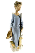 Standing angel figurine in light blue dress, holding broom and gold leaf basket