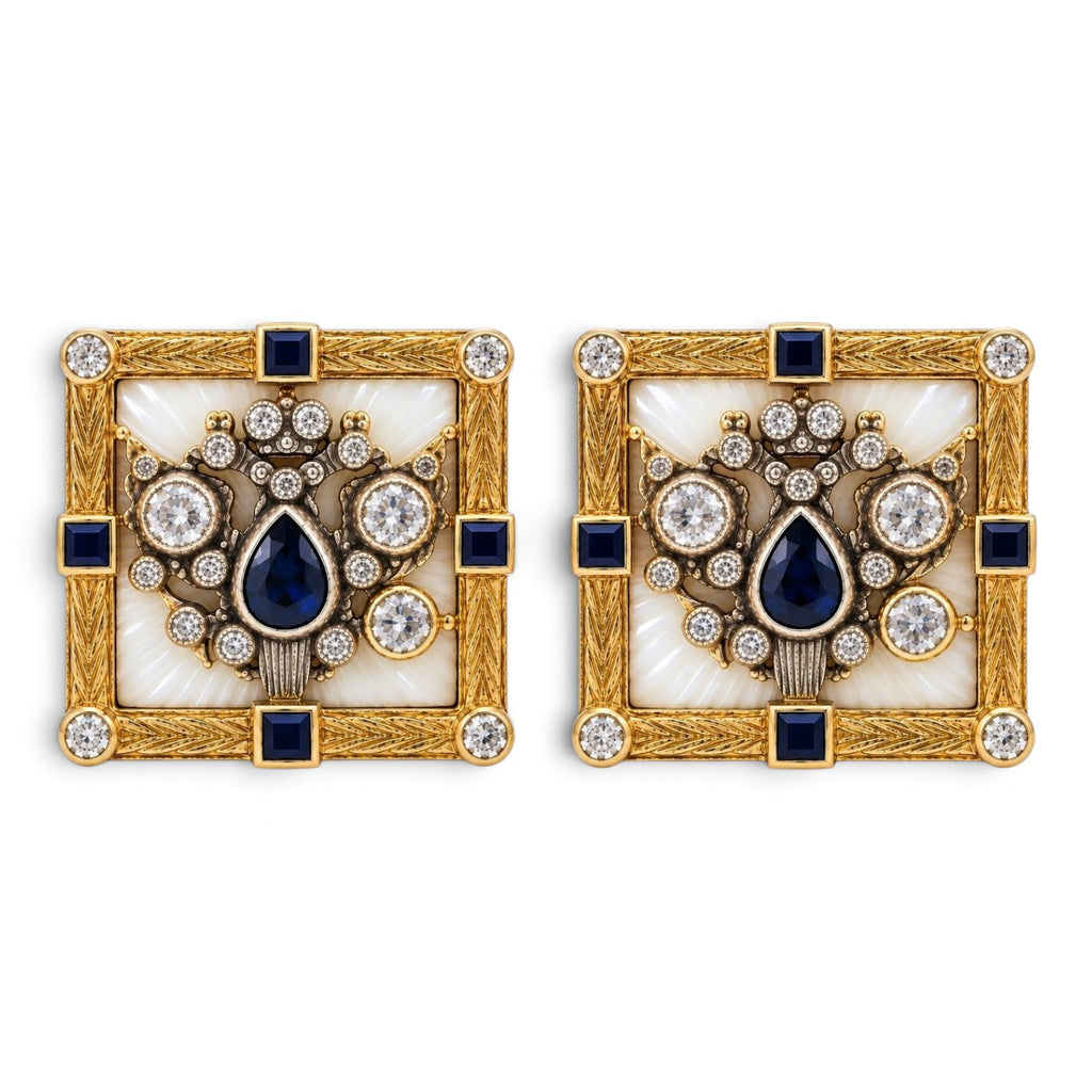 Two square gold cufflinks with blue center stone, halo of clear gems, and black accents